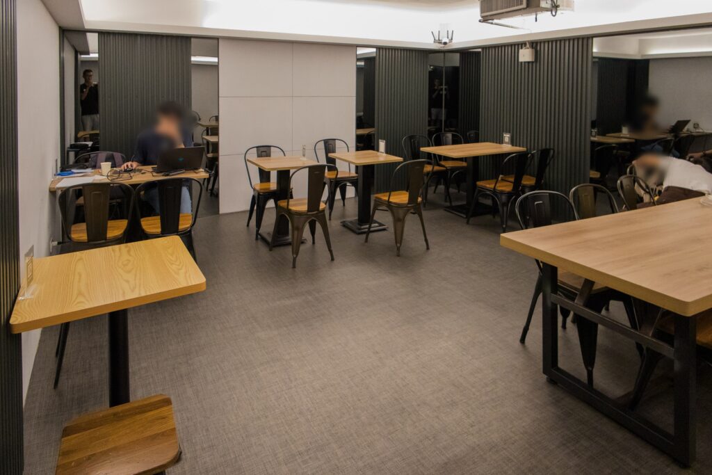 B1 座位區，以木質桌面搭配黑色鐵椅，桌距寬敞，設有雙人與多人座位，也有人帶筆電工作。