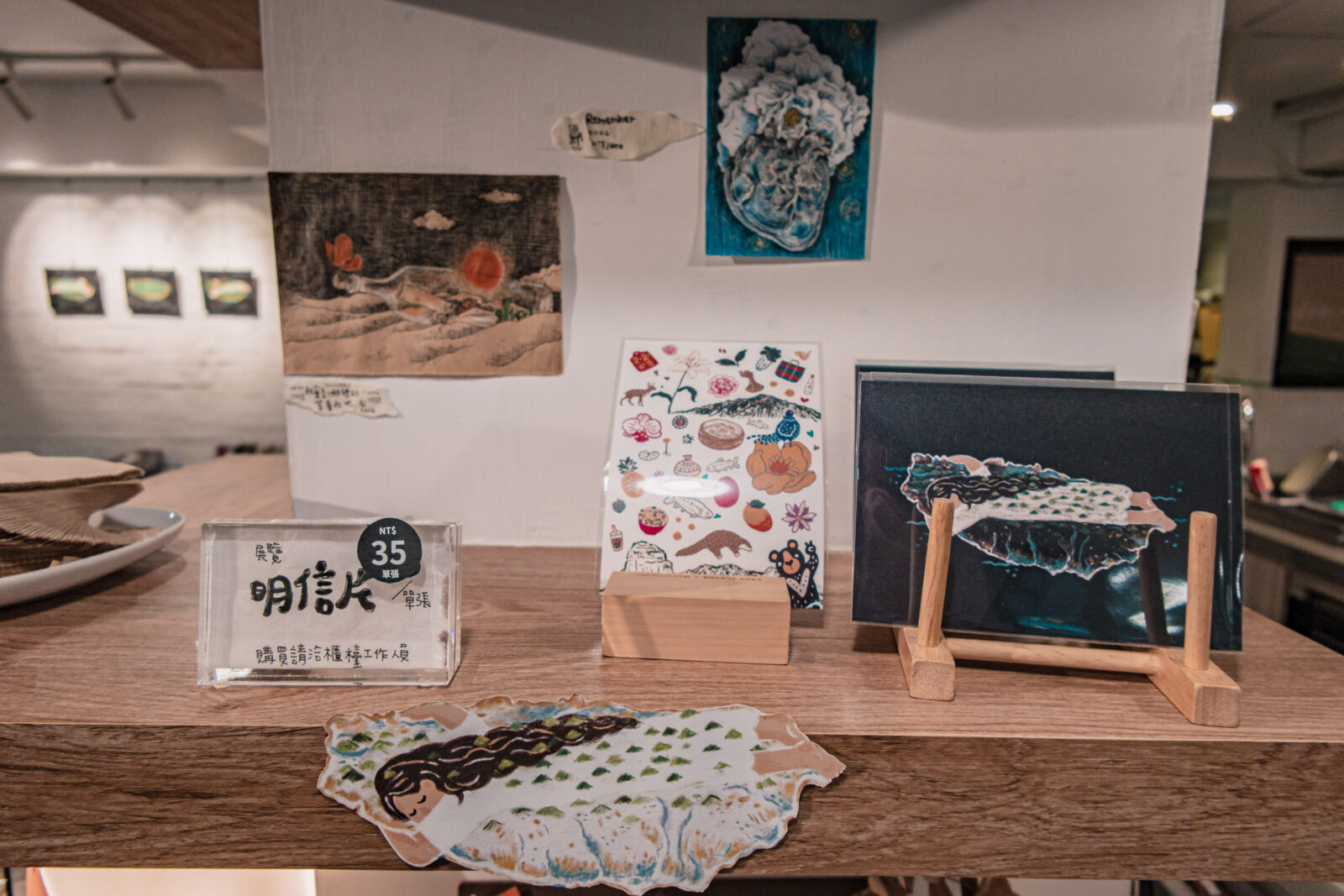 ForgoodCafe 好多咖啡吧台旁的文創小物與明信片展示，牆面陳列插畫作品與手作設計品