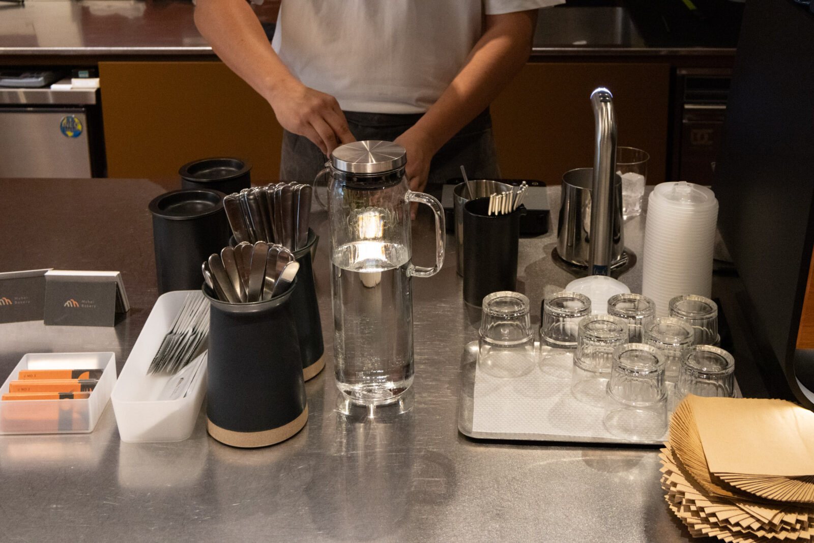 Muhei Bakery 暮黑烘焙咖啡吧檯，店員正在金屬工作檯準備咖啡飲品