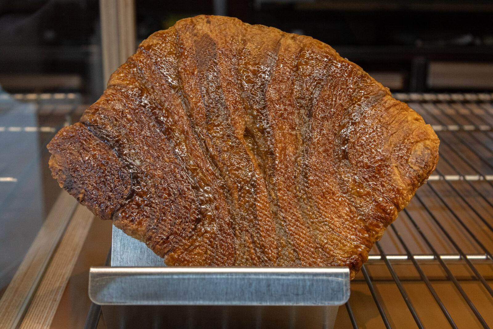 Muhei Bakery 暮黑烘焙扁可頌近拍，扁平酥皮烤至金黃焦脆，表面帶有亮澤