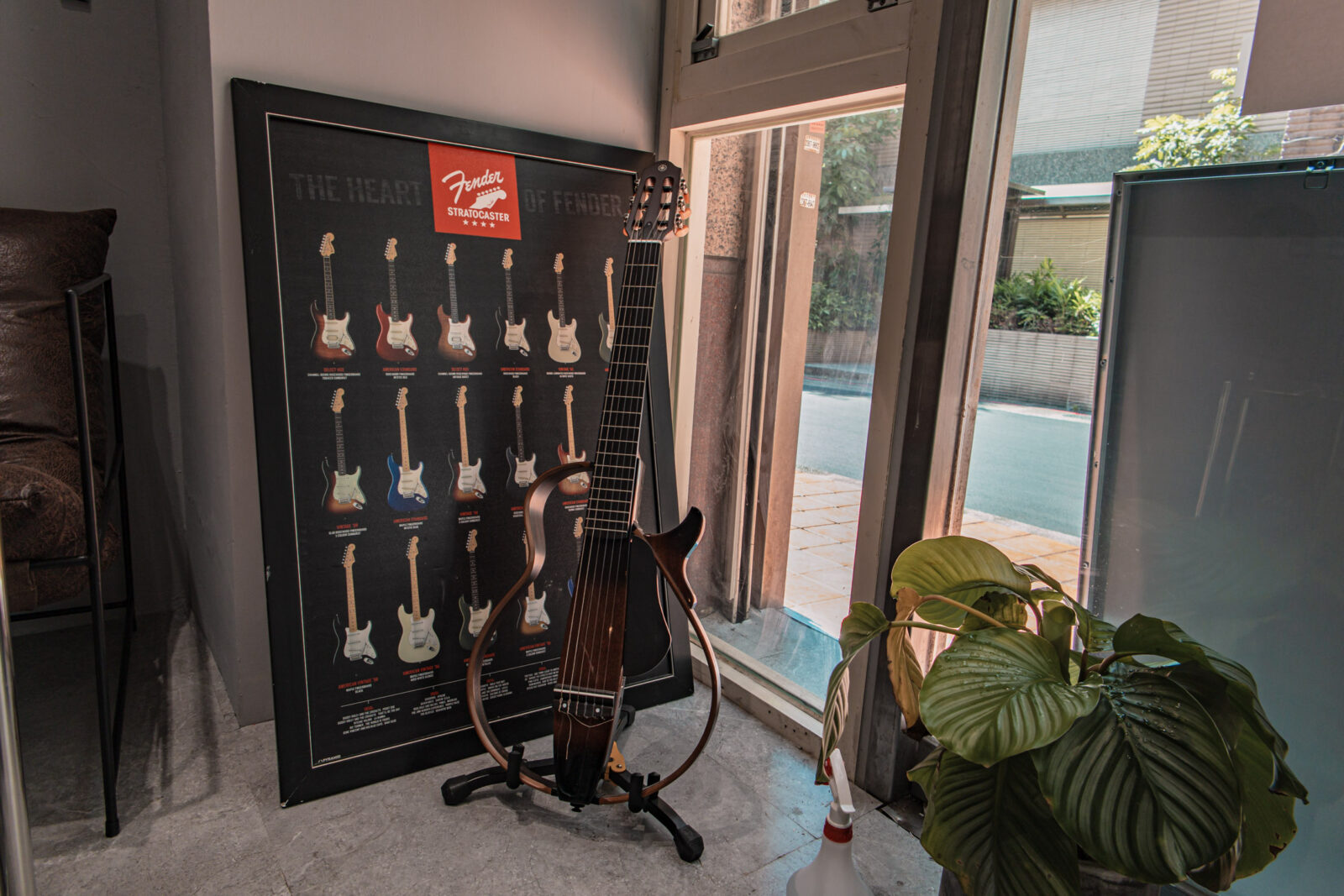 Lee’s Coffee 古亭店吉他展示,窗邊擺放吉他與 Fender Stratocaster 海報,呈現店內鮮明的音樂元素