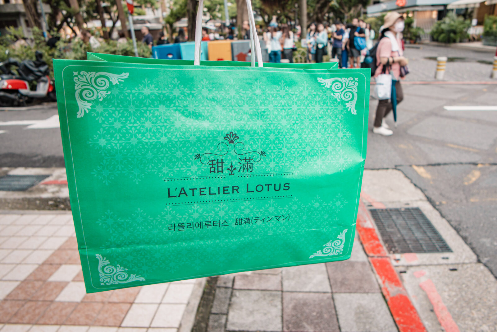 甜滿 L'Atelier Lotus 綠色伴手禮提袋，購買完成後店外仍可看到不少排隊人潮